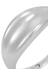 Polerad silverring med en slät, böjd yta och subtil glans. Har en liten klar sten nära ringen. Enkel, modern design.