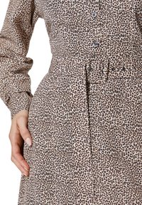 Leopardprint shirtjurk van lichtgewicht stof. Beschikt over een ceintuur in de taille, lange mouwen en knoopsluitingen aan de voorkant.