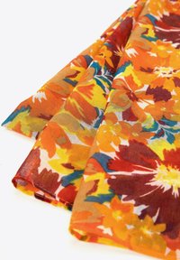 Tessuto floreale in tonalità di arancione, giallo e rosso con accenti verdi. Leggero, con una texture trasparente e grandi motivi floreali vivaci.
