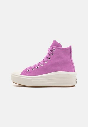 Baskets montantes en daim violet avec semelle épaisse en caoutchouc blanc, bout blanc et lacets violets assortis sur fond uni.