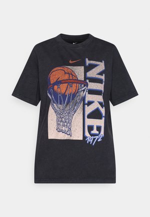 Črna bombažna majica s kratkimi rokavi, ki vključuje grafiko košarke v košu ter besedilom "NIKE" in "1972". Oblika s kratkimi rokavi in krojnim ovratnikom.