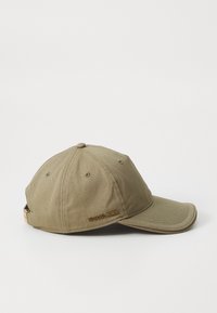 Cappello da baseball color khaki in cotone con visiera curva, dotato di piccole occhielli metallici e logo dorato "MICHAEL KORS" sul lato.