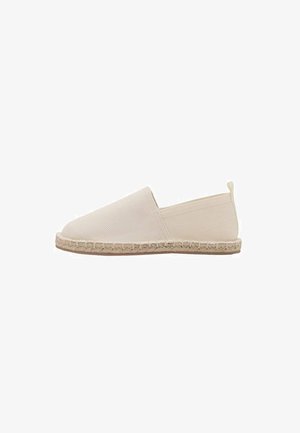 Béžová plátěná slip-on obuv s kulatou špičkou, jutu rope podešví a bez viditelného kovového prvku. Minimalistický design s texturovaným svrškem.