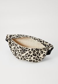 Leopardų raštuotas juosmens krepšys beige ir juodos spalvos. Pagamintas iš kanvaso, turi užtrauktuko uždarymą, nepapuoštą vidų ir reguliuojamą diržą.