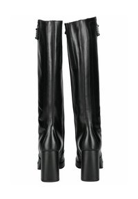 Bottes noires en cuir montantes avec un talon bloc, présentant une texture lisse et des détails de couture à l'arrière et sur les côtés.