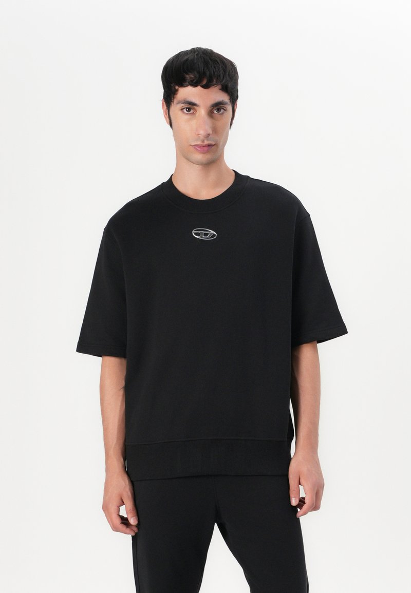 Sweatshirt noir oversize en mélange de coton, avec un col rond et des manches courtes. Détail de logo sur le devant en argent.