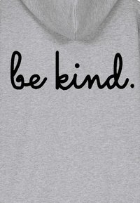 Hall hall kapuutsiga dressipluus, mille seljal on suured mustad kursiivkirjas sõnad "be kind". Pehme kangas, millel on kergelt kirju tekstuur.