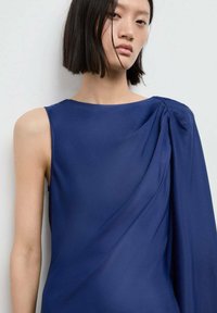 Robe bleu marine en tissu lisse, dotée d'un design asymétrique à une épaule avec des détails drapés et une manche structurée.