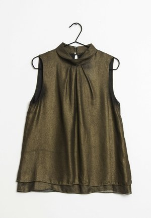 Bezramkowy, ciemnozłoty top z wysokim kołnierzem, plisowanym przodem i przezroczystą teksturą. Wiszący na czarnym metalowym wieszaku na tle białym.