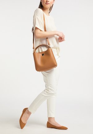 Brown leather bucket bag with a top handle and adjustable strap. Smooth texture, subtle logo, and protective metal feet on the bottom.