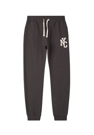 Pantaloni della tuta grigio scuro realizzati in tessuto morbido. Vita elasticizzata con coulisse bianca. Presenta un logo "NC" bianco sulla coscia sinistra.