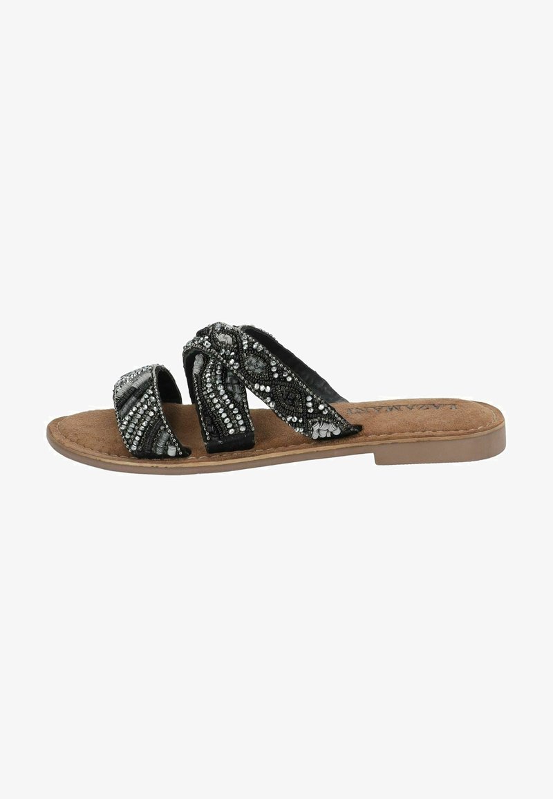 Black slide sandals with two straps featuring intricate beadwork and a textured design on the upper. Cork footbed with a flat sole.