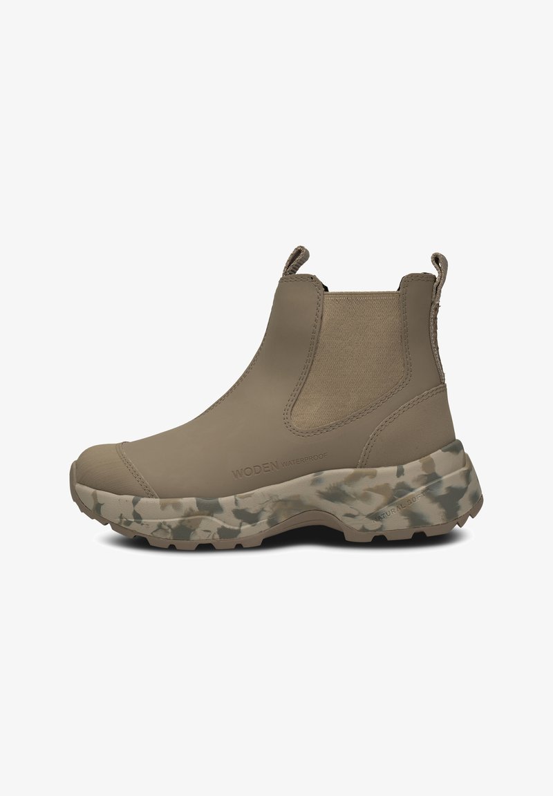 Botín de tobillo impermeable beige con paneles laterales de elastano, parte superior texturizada y suela de camuflaje gruesa. Cuenta con lengüetas para poner y quitar fácilmente.