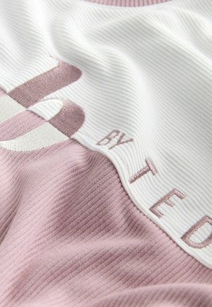 Bomuldsblandet stof med et pink og hvidt design og ribbet struktur. Broderede bogstaver "BY TED" i en kontrasterende farve.