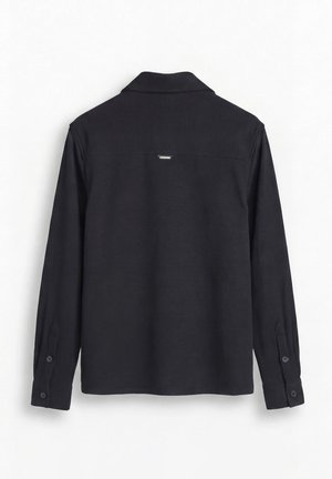 Zwart shirt met lange mouwen, gezien van achteren, met een kraag, knoopmanchetten en een klein reflecterend detail onder de kraag.