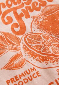 Baumwollstoff mit einem strukturierten Design, das orangefarbene Grafiken von Orangen und Blättern zeigt, zusammen mit dem Text "Frisch" und "Premium-Obst".