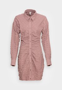 Vestido estruturado rosa com gola, mangas longas e lados franzidos, apresentando um padrão de linhas horizontais salientes.
