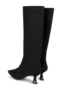 Botas de ante negras hasta la rodilla con puntera afilada y un exclusivo tacón acampanado acentuado en metálico. Textura suave con un diseño sin costuras.