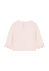 Maglietta a maniche lunghe rosa chiaro con polsini arricciati e chiusura a bottoni sul retro. Materiale in cotone morbido con una sottile texture.