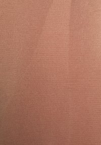 Žebrovaná pletenina ve tlumené terakotové barvě, s hladkým textura a mírným leskem, s různými vzory žebrování.