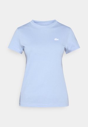 Lichtblauw katoenen T-shirt met een ronde hals, korte mouwen en een klein wit logo aan de bovenkant links. Soepele textuur, getailleerd model.