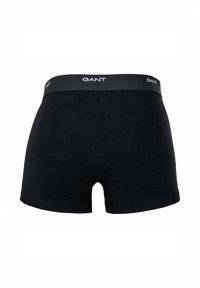 Black cotton boxer shorts with a grey elastic waistband featuring the "GANT" logo in white. Basic design with a smooth texture.