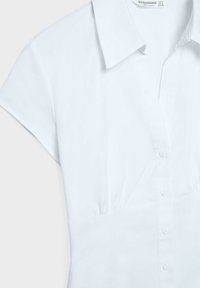 Bílá halenka s krátkým rukávem, límečkem, knoflíky vpředu a mírným řasením pod prsy, zobrazena na světlém pozadí.