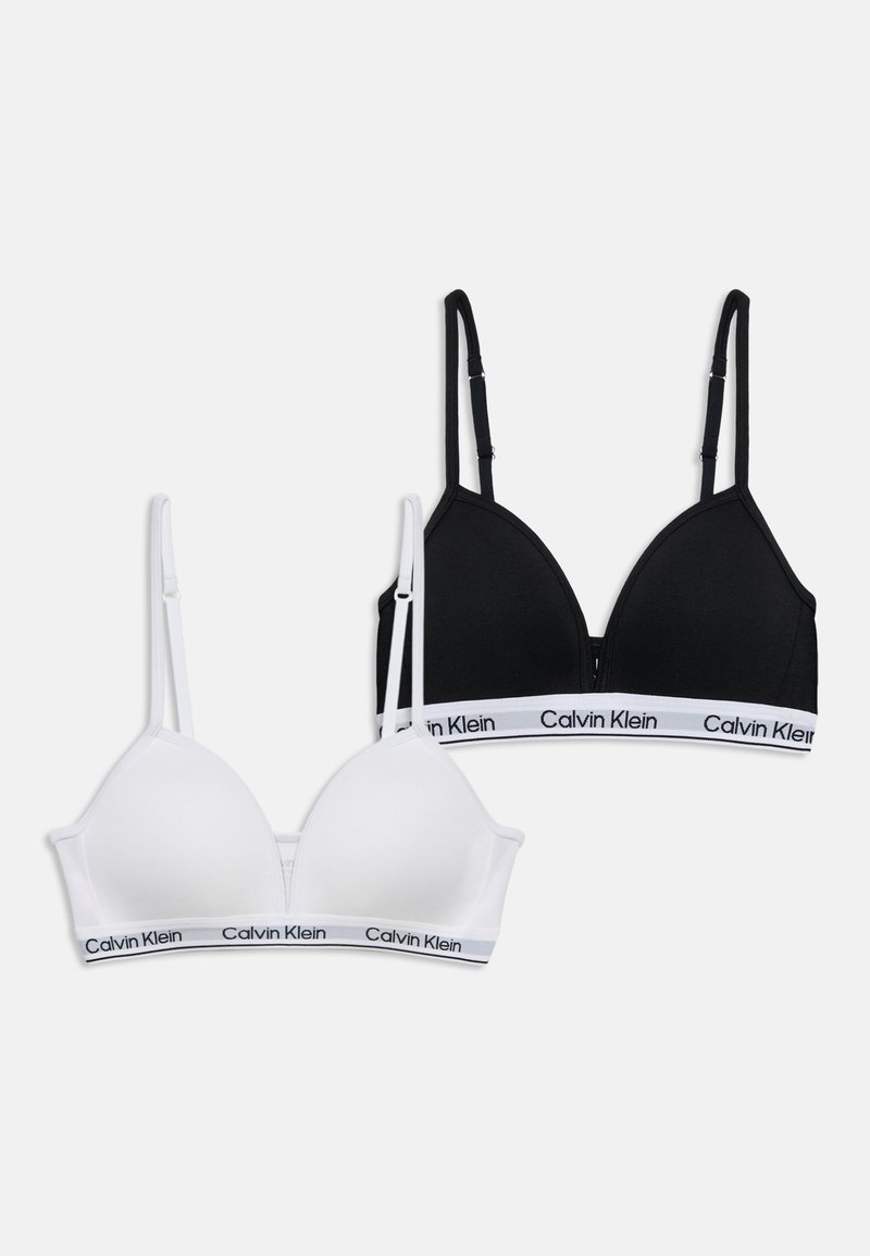 Deux bralettes Calvin Klein, une noire et une blanche, toutes deux avec des bretelles réglables et des bandes avec logo en bas.