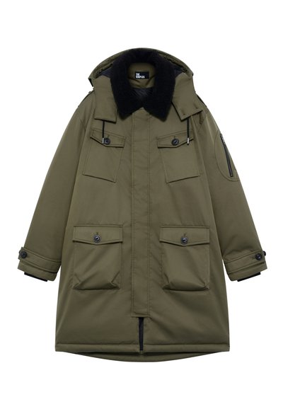 Oliwkowy parka z kołnierzem z sztucznego futra, wieloma przednimi kieszeniami i kieszenią na suwak na rękawie. Wykonana z trwałej tkaniny, o dłuższym kroju.
