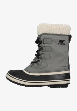 Botte étanche gris avec semelle en caoutchouc noir, col en fausse fourrure blanche, design à lacets et logo Sorel sur le côté. Présente un tissu texturé.