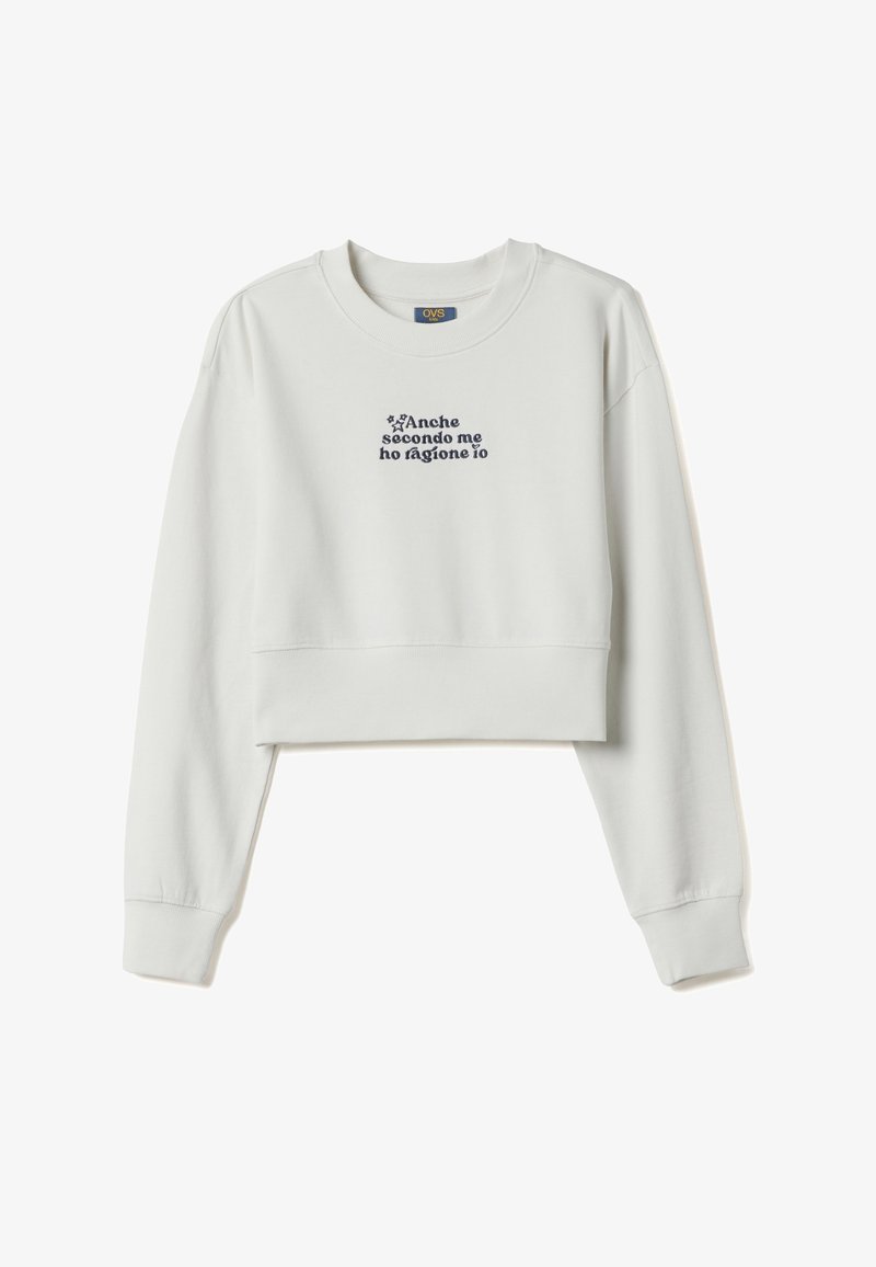 Sweat-shirt gris clair court en coton doux. Présente un texte bleu marine et des accents d'étoiles sur le devant. Manches longues avec poignets côtelés.