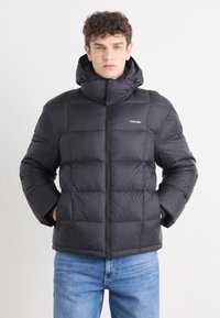 Must must jacket kõrge krae ja lukuga. Omab tikitud sektsioone ja logo vasakul rinnal. Kapuutsiga disain.