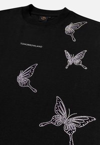 Black sweatshirt featuring a "TOMORROWLAND" logo and multiple butterfly designs embellished with sparkling rhinestones in varying sizes.