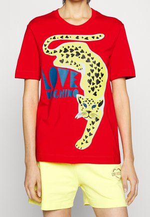 Rood T-shirt met een gele luipaard bedekt met zwarte hartjes en blauwe tekst "Love Moschino," gecombineerd met gele korte broek met klein logo.