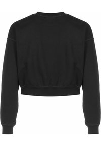 Sudadera corta negra con mangas largas, puños acanalados y cuello redondo. Textura suave con costuras en contraste a lo largo de las costuras.