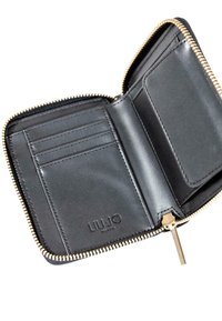Portafoglio in pelle nera con zip a giro aperto per mostrare gli scomparti per carte e la tasca per monete, con zip dorata e "LIU JO MILANO" impresso all'interno.