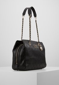 Sac Guess noir avec surface à motif en relief, chaînes dorées, poche zippée sur le côté et plaque logo de la marque à l'avant.