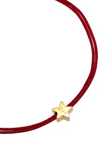 Collier à cordon rouge avec un pendentif étoile doré orné de détails gravés. La forme du pendentif est une étoile à cinq branches, offrant un design simple mais distinct.