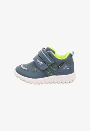 Blaue und graue Sneakers mit einem Klettverschluss, strukturierter Stoff, grünen Akzenten und einer weißen Gummisohle mit einem Zickzackmuster.
