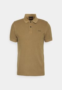 Polo khaki en coton, avec un col classique, une patte de boutonnage à deux boutons, et un logo discret brodé sur la poitrine.