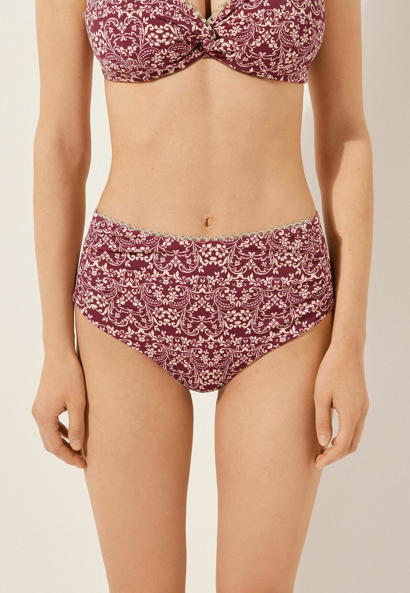 Bikini-set i bordeaux med blommönster i krämfärgad. Toppen har en tvistdesign och den högmidjade botten har en mjuk textur.