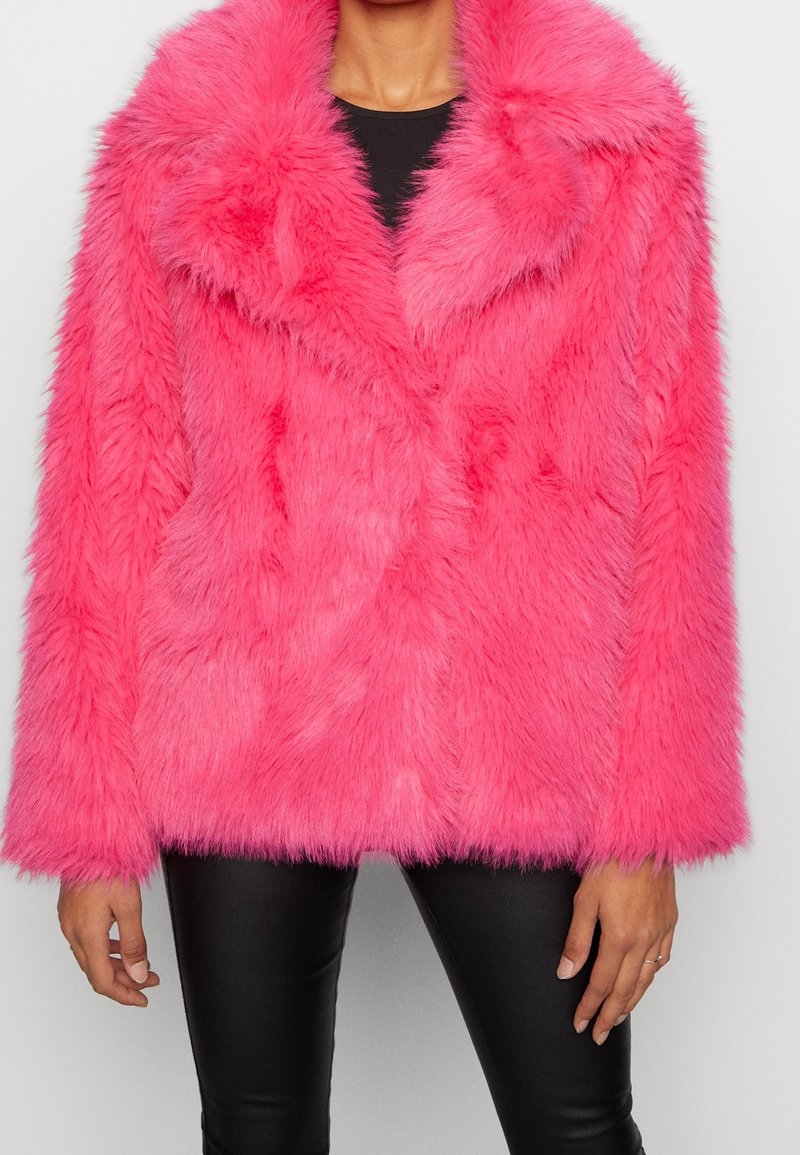 Różowa kurtka z futra syntetycznego z szerokim kołnierzem, długimi rękawami i luźnym fasonem. Teksturowany, puszysty materiał pokrywa całą powierzchnię.