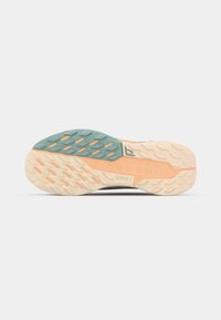 Shoe sole with patterned grip features; includes a teal section, peach accents, and textured areas for traction. Yellow branding visible.