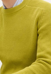 Maglione lavorato a maglia di un vivace verde lime, caratterizzato da un design a costine testurizzato, scollatura rotonda e polsini e orlo a coste.