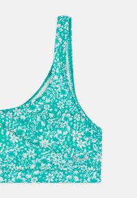 Türkiz virágmintás bralette vékony pántokkal, egy szilárd övvel és puha tapintással. Fehér virágminták az egész felületen.