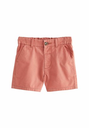 Pantaloni cuffia color ruggine in cotone, dotati di chiusura a bottoni, due tasche frontali e dettagli cuciti sulla cintura e sul bordo.