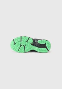 Semelle de chaussure de course noire avec un design texturé, dotée d'un caoutchouc vert vif et d'accents noirs pour une adhérence et une flexibilité optimales.