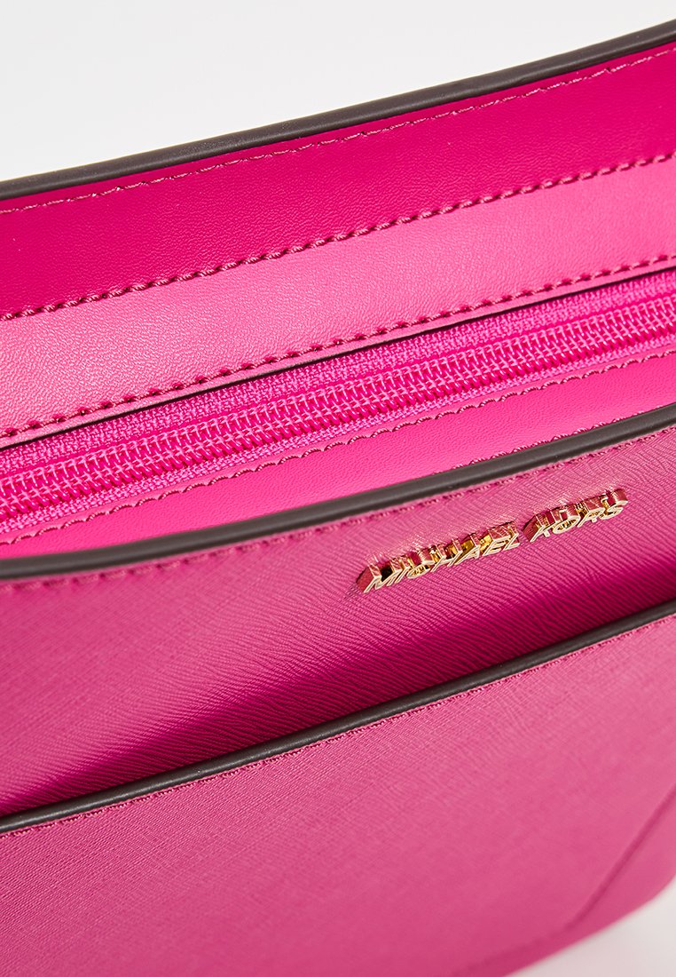 Roze lederen handtas interieur met een ritszak en een gouden logo. Textuur en bruine accenten benadrukken het ontwerp.