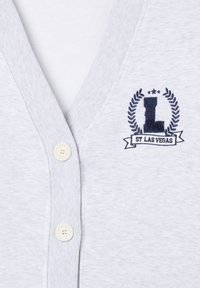 Cardigan grigio chiaro con scollo a V, rifinitura a coste strutturata, bottoni color crema e logo ricamato blu navy con foglie di alloro e testo.