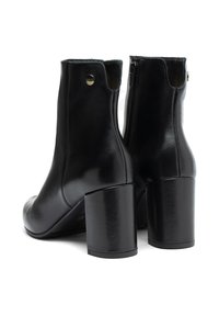 Mustat nahka nilkkurit, joissa on sileä pinta, pyöreä kärki ja paksu korkea korko; varustettu sivuvetoketjulla ja pienellä logotiedolla.